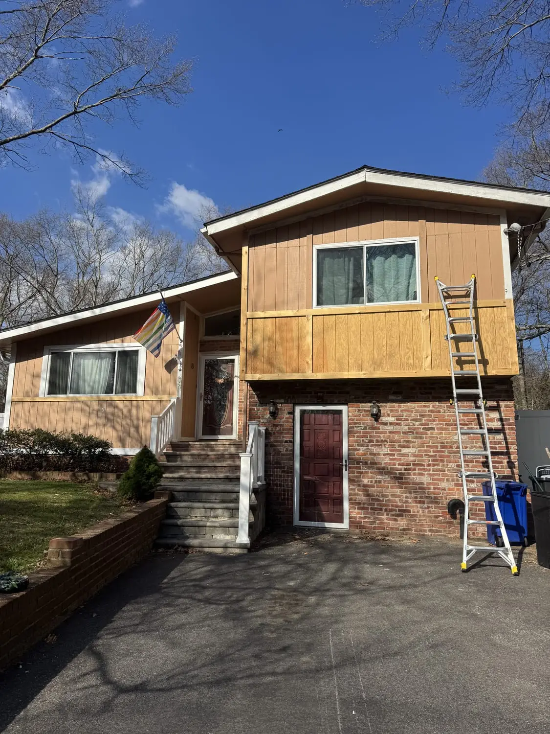 Exterior repaint underway with a ladder on a Long Island home