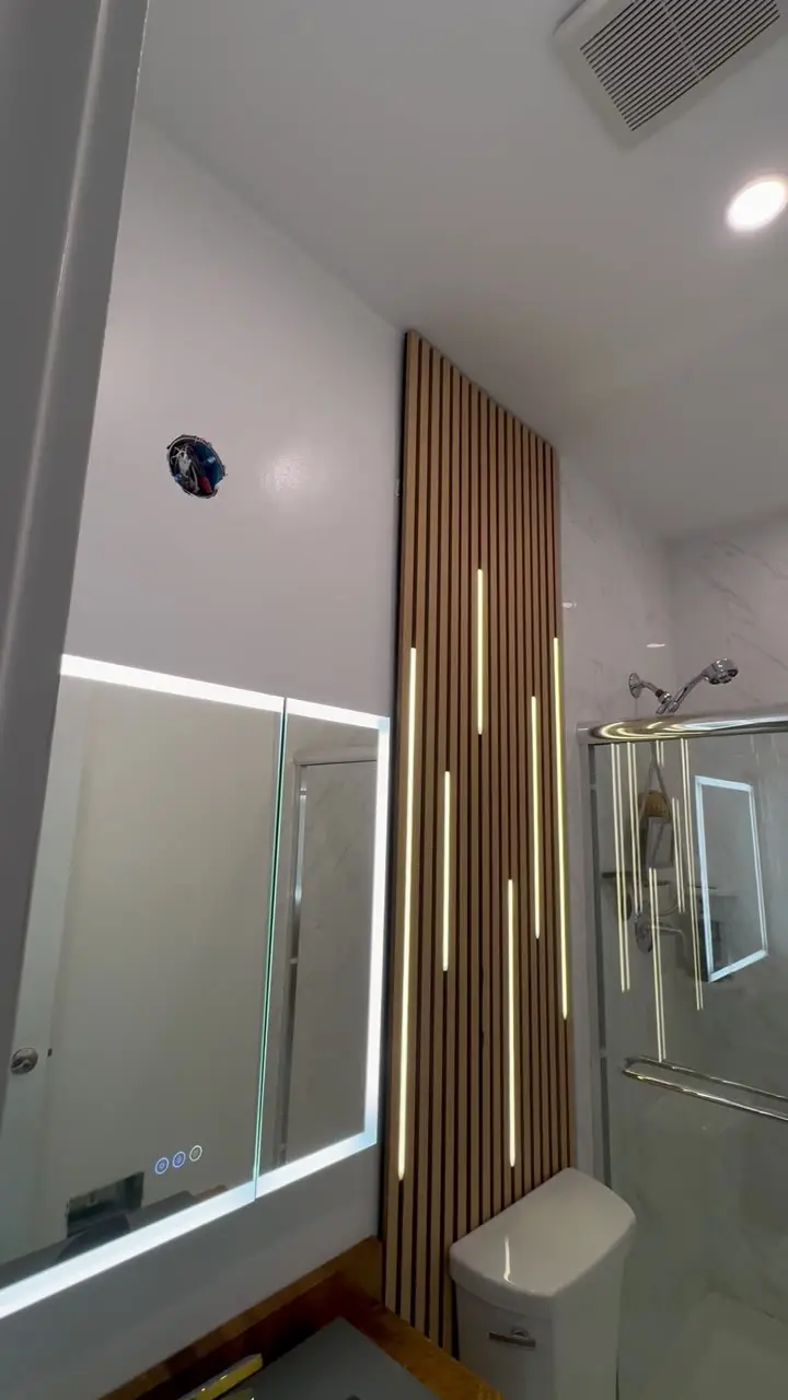 Modern bathroom with a wood slat feature wall, marble shower and freshly painted white trim