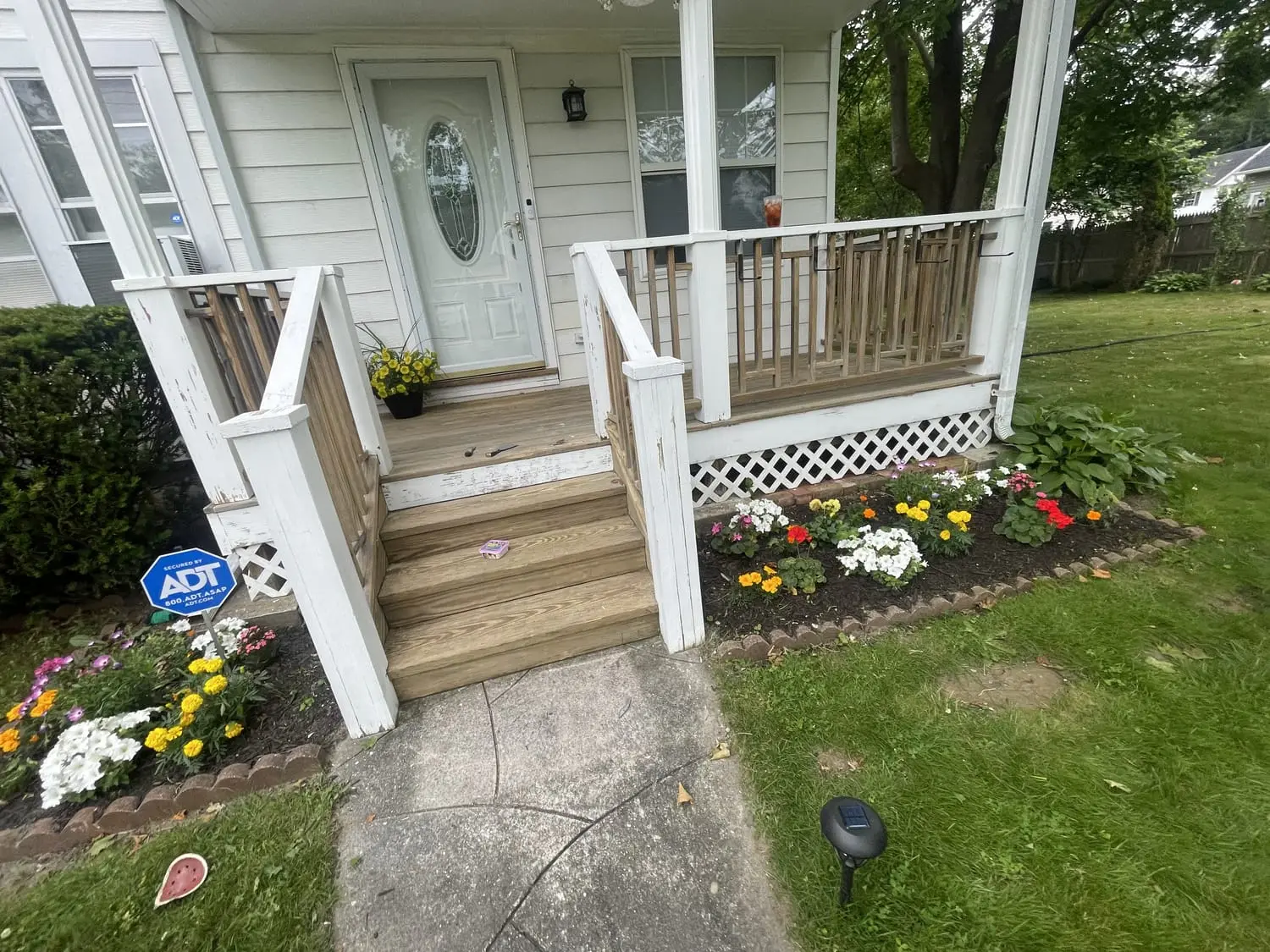 Front porch with freshly painted white railings, steps and spring flowers