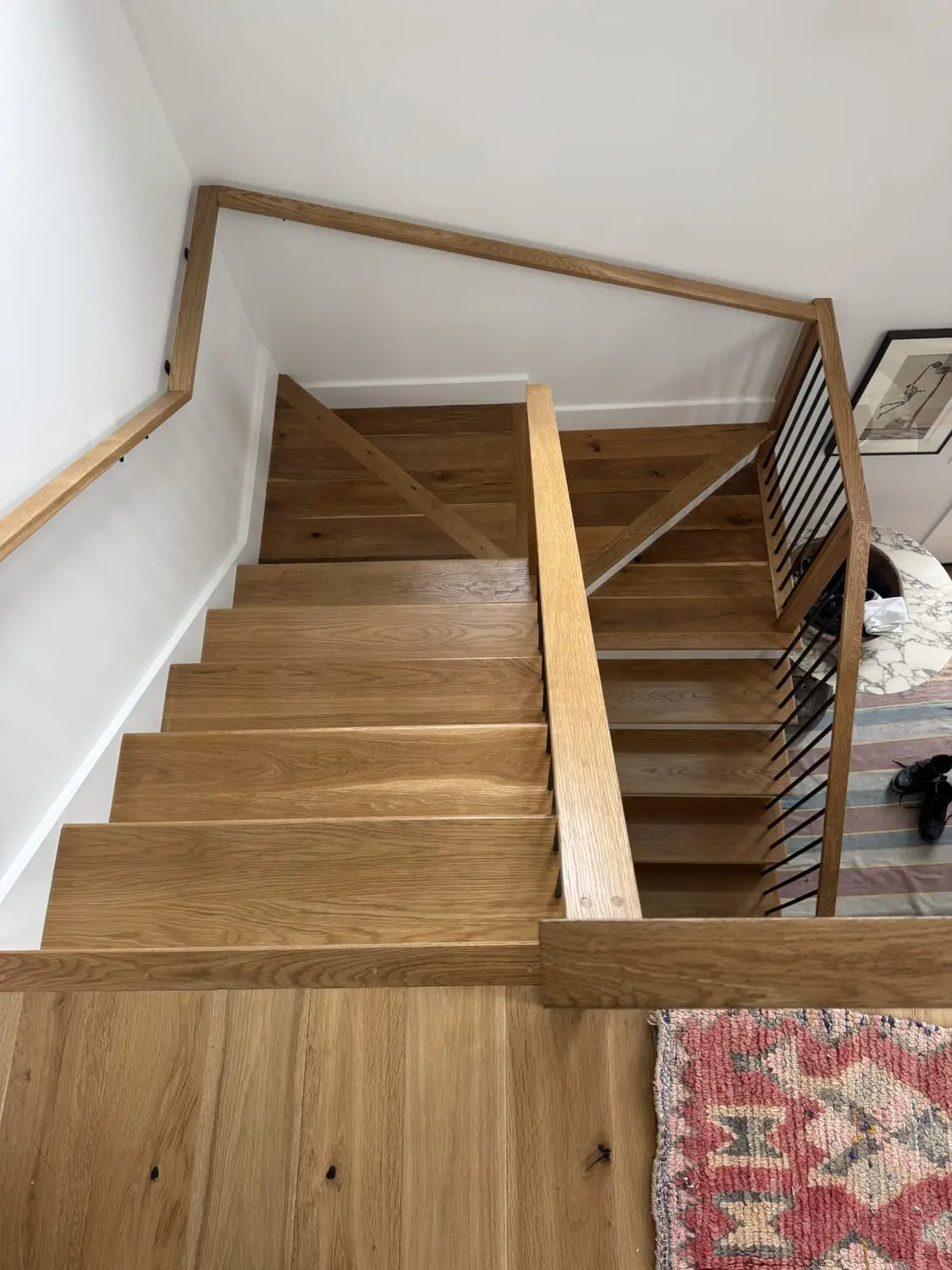 Modern staircase with freshly painted risers and a wood and cable railing